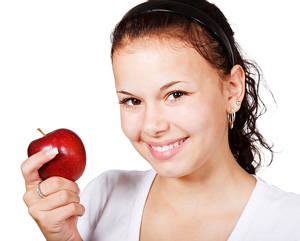 Glad kvinde spiser æble